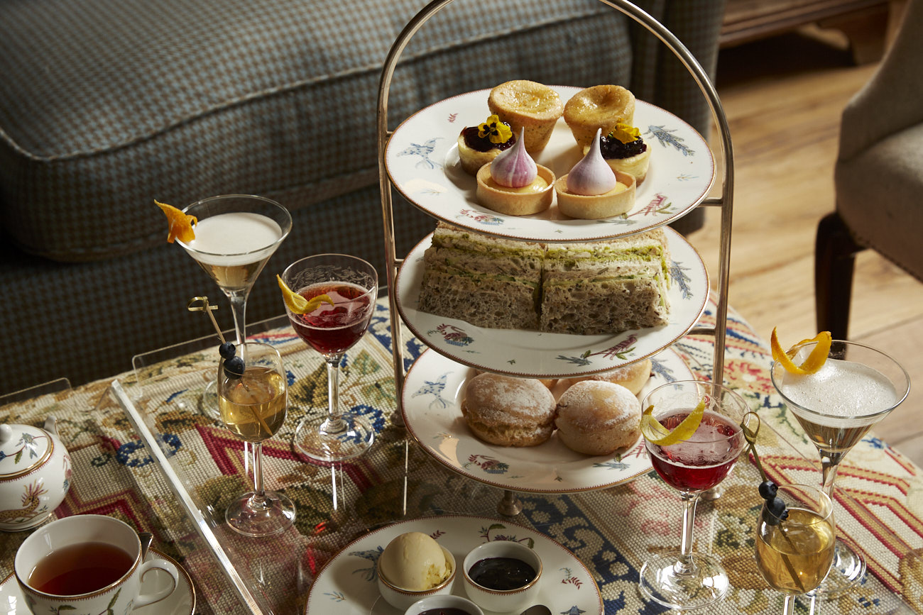 An afternoon tea setup with a sofa next to the table.